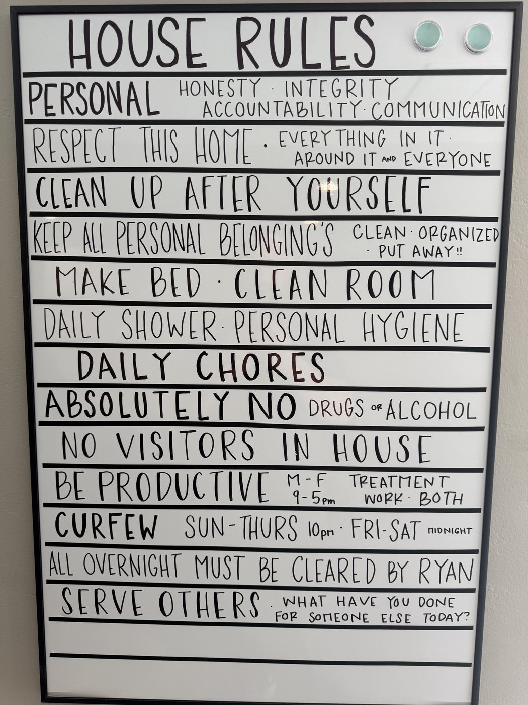 Phoenix Rising house rules, handwritten on a whiteboard hanging in one of the houses
