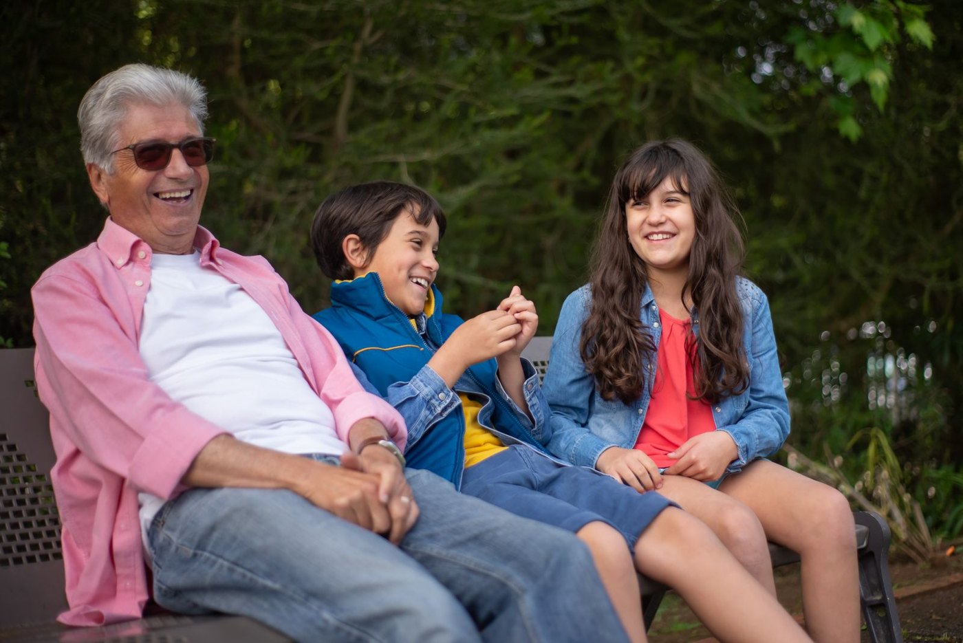 A grandfather laughing with his grandchildren
